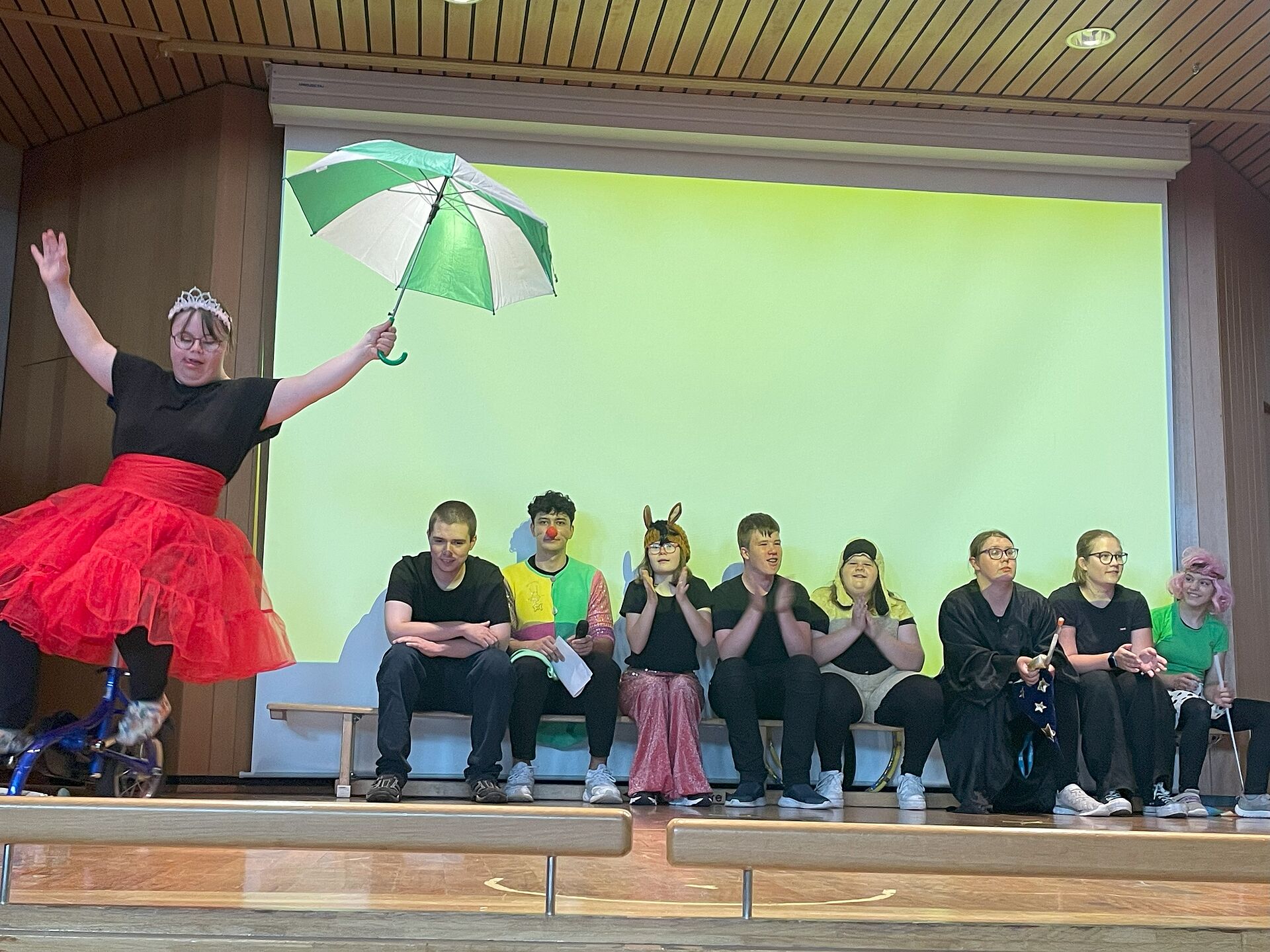 Aufführung Theatergruppe, Schülerin mit Schirm im Vordergrund